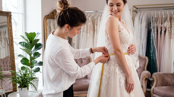 Bride getting measured in her wedding dress