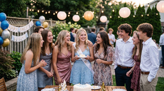 A smiling group of teenagers gather around a girl in a blue dress holding a slice of cake at a outdoor Sweet 16 party.